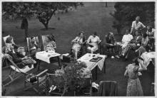 Group of sixteen PPU men and women seated outdoors.