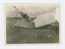 Black and white photograph wrecked plane on the ground.