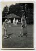 Mazo de la Roche playing croquet with another woman while wearing gas masks