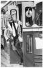 Jack McClelland wearing a coat with various book covers, standing in a streetcar